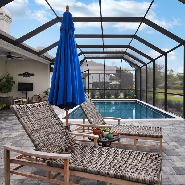 two lounge chairs by pool in lanai