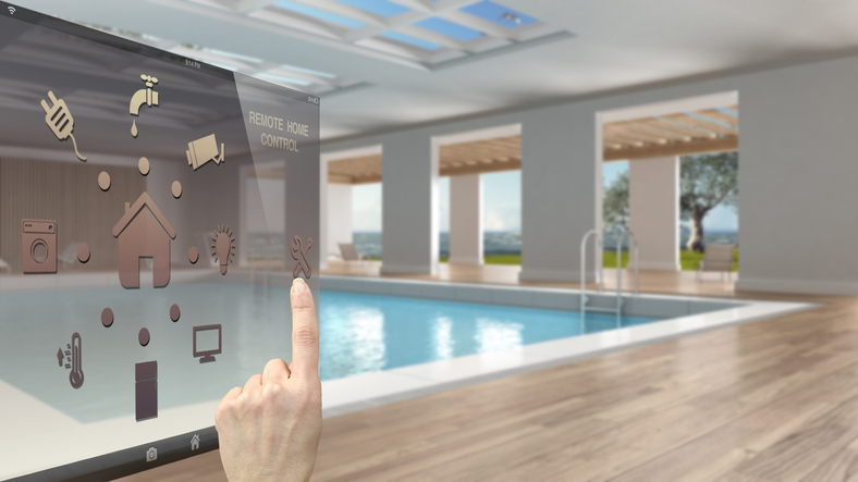 Smart home control concept, hand controlling digital interface from mobile app. Blurred background showing interior swimming pool, architecture interior design
