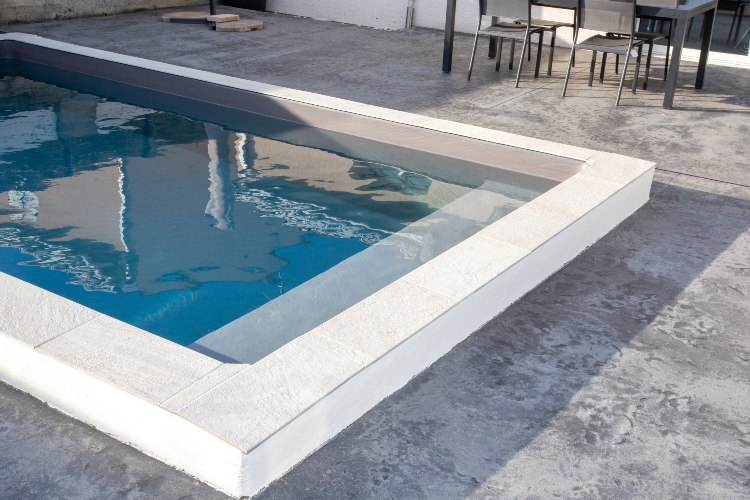 contemporary cement white grey swimming pool with staircase and modern border with blue water
